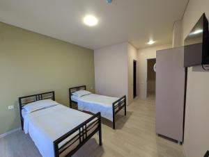 a room with two beds and a flat screen tv at Compass hotel in Kobuleti