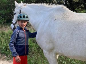 a young boy standing next to a white horse at Le Verger in Gordes