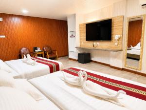 a hotel room with two beds and a flat screen tv at SS Hotel Seremban in Seremban