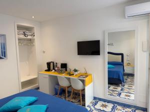 a room with a desk and a bed and a mirror at La Piccola Suite in Anacapri