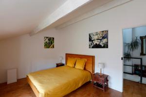 a bedroom with a large bed with yellow pillows at Les Airis, maison de vacances écologique in Avignon