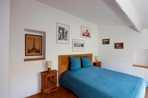 a bedroom with a blue bed and pictures on the wall at Les Airis, maison de vacances écologique in Avignon