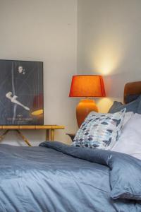 a bedroom with a bed and a table with a lamp at Lux PIGALLE in Argenteuil