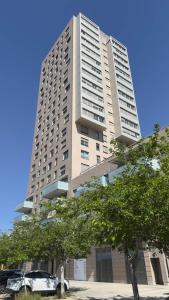 a tall building with a car parked in front of it at Boutique Room - Plaza Tower in Valencia