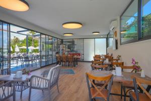 a restaurant with tables and chairs and windows at A Suite Side in Side