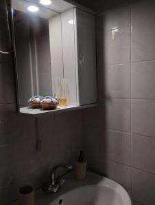 a bathroom sink with a medicine cabinet and a mirror at Αλέξανδρος 4 in Myrina
