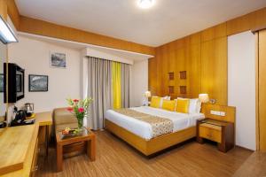 a hotel room with a bed and a desk at Meadows Residency in Ooty