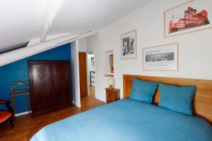 a bedroom with a blue bed with a wooden headboard at Les Airis, maison de vacances écologique in Avignon