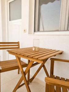 a wooden table with a cup on it next to a bench at Tolo at sea - Nova in Tolo