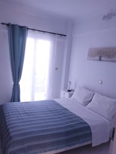 a bedroom with a large bed with a window at Αλέξανδρος 4 in Myrina