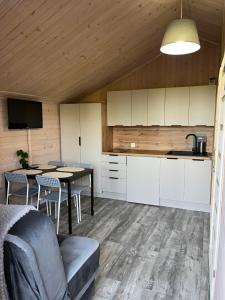 a kitchen and dining room with a table and chairs at Domki Na Skraju in Stegna