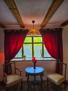 ein Zimmer mit zwei Stühlen und einem Tisch mit Fenster in der Unterkunft CasaGeo Cheile Nerei in Socolari