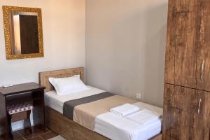 a small bedroom with a bed and a mirror at BESQALA in Nukus