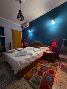 a bedroom with a large bed and a blue wall at John's House in Chalkida