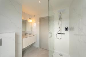a white bathroom with a shower and a sink at The Lochalsh Hotel - Isle of Skye in Kyle of Lochalsh +55 photos