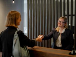 a woman shaking hands with a woman in front of a desk at IMLAUER Palais Mirabell in Salzburg