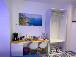 a kitchen with a counter with two stools and a table at La Piccola Suite in Anacapri