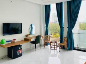a living room with a table and chairs and a television at VyVy House Hotel in Tuy Hoa