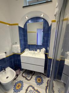 a blue tiled bathroom with a sink and a toilet at La Piccola Suite in Anacapri +49 photos
