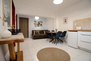 a kitchen and living room with a table and chairs at Roys Blu in Kavos