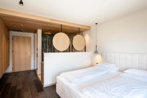 a bedroom with two beds and two mirrors on the wall at Hotel Öhlerhof in Lagundo +22 photos