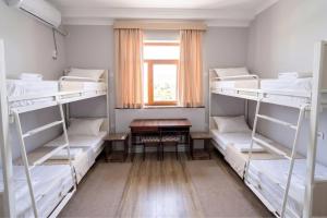 a room with four bunk beds and a table at BESQALA in Nukus