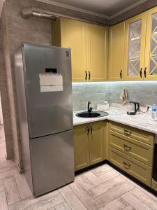 a kitchen with a stainless steel refrigerator and yellow cabinets at Pearl KadoRR in Liski