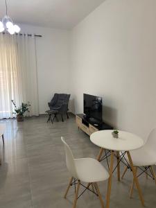 a living room with a table and chairs and a tv at Delijorgji Sunrise 4 in Tirana