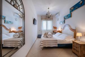 a bedroom with two beds and a mirror at Lula Hotel - Ex Love & Fama Hotel in Sabaudia