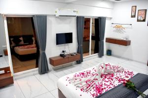 a living room with a bed and a television at Infinity Hotel in Rajkot