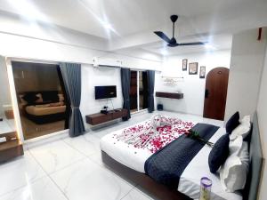 a bedroom with a large bed and a television at Infinity Hotel in Rajkot +16 photos