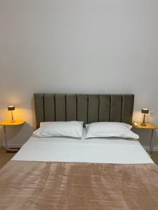 a bedroom with a large bed with two side tables at Delijorgji Sunrise 4 in Tirana