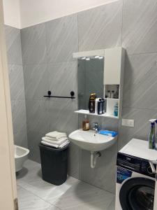 a bathroom with a sink and a toilet and a mirror at Delijorgji Sunrise 4 in Tirana