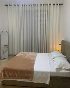 a bedroom with a large bed in front of curtains at Delijorgji Sunrise 4 in Tirana