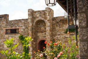 an old stone building with a door and flowers at Lahuta e Vjeter Agroturizem in Laç +47 photos