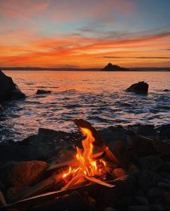 a camp fire on the beach at sunset at Spacious Studio by the sea, Garden & Parking in Marazion
