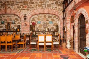 a restaurant with tables and chairs in a brick wall at Lahuta e Vjeter Agroturizem in Laç