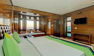 a bedroom with a large bed and a television at Hotel Monal Inn, Pangot Wildlife and Bird Sanctuary in Nainital +27 photos