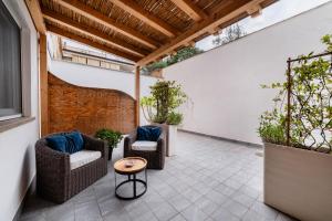 an outdoor patio with wicker chairs and a table at Lula Hotel - Ex Love & Fama Hotel in Sabaudia