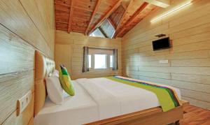 a bedroom with a white bed in a wooden room at Hotel Monal Inn, Pangot Wildlife and Bird Sanctuary in Nainital