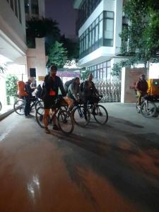 a group of people riding bikes down a street at Peaceful Paradise Homestay in Hai Phong