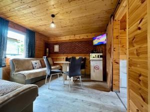 a living room with a couch and a table and chairs at Rajski Domek Rajsko in Bożkowice