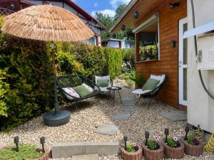 a patio with two chairs and an umbrella at Rajski Domek Rajsko in Bożkowice