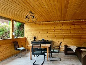 a patio with a table and chairs and a bike hanging from a ceiling at Rajski Domek Rajsko in Bożkowice