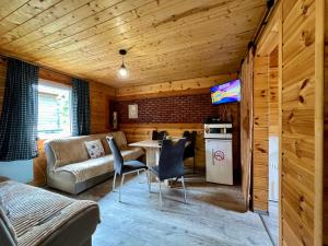 a living room with a couch and a table and chairs at Rajski Domek Rajsko in Bożkowice +8 photos