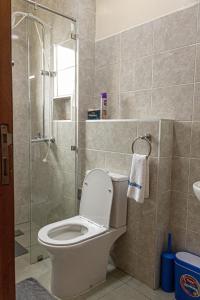 a bathroom with a toilet and a glass shower at PrimeCitySuites in Nakuru