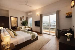 a bedroom with a large bed and a balcony at Onyx Suite Luxury Apartment # Lift # Garden # Ac rooms # Private Parking # Near Prem Mandir # Located Inside- Omaxe Eternity Vrindavan # in Vrindāvan +17 photos