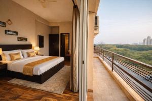 a bedroom with a bed and a balcony with a view at Onyx Suite Luxury Apartment # Lift # Garden # Ac rooms # Private Parking # Near Prem Mandir # Located Inside- Omaxe Eternity Vrindavan # in Vrindāvan