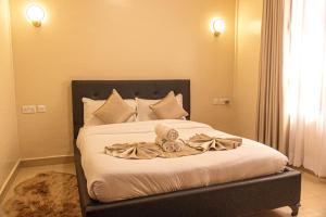 a bed with a blanket and two stuffed animals on it at PrimeCitySuites in Nakuru