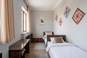 a room with two beds and a bench in it at BESQALA in Nukus